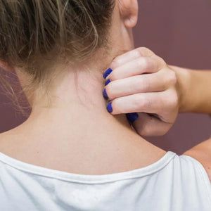 Young lady scratching her neck.