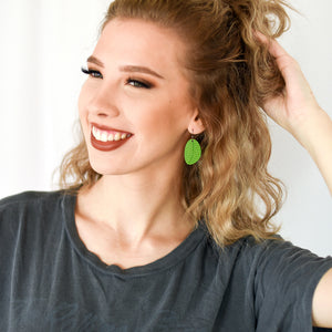 Girl wearing small leaf earrings in lime green by ColorUpLife