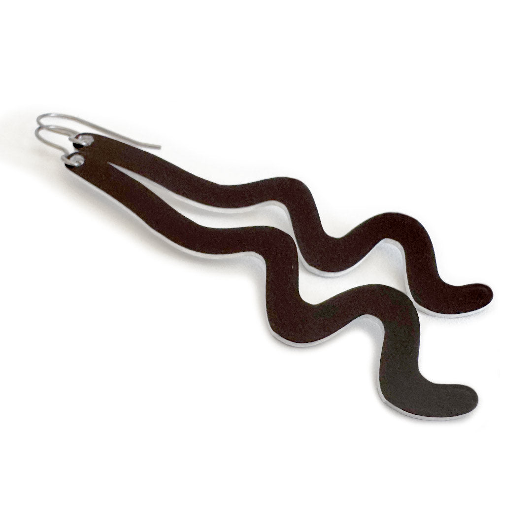 A pair of wavy, black dangle earrings made of aluminum with silver-tone titanium ear wires, shown on a plain white background.