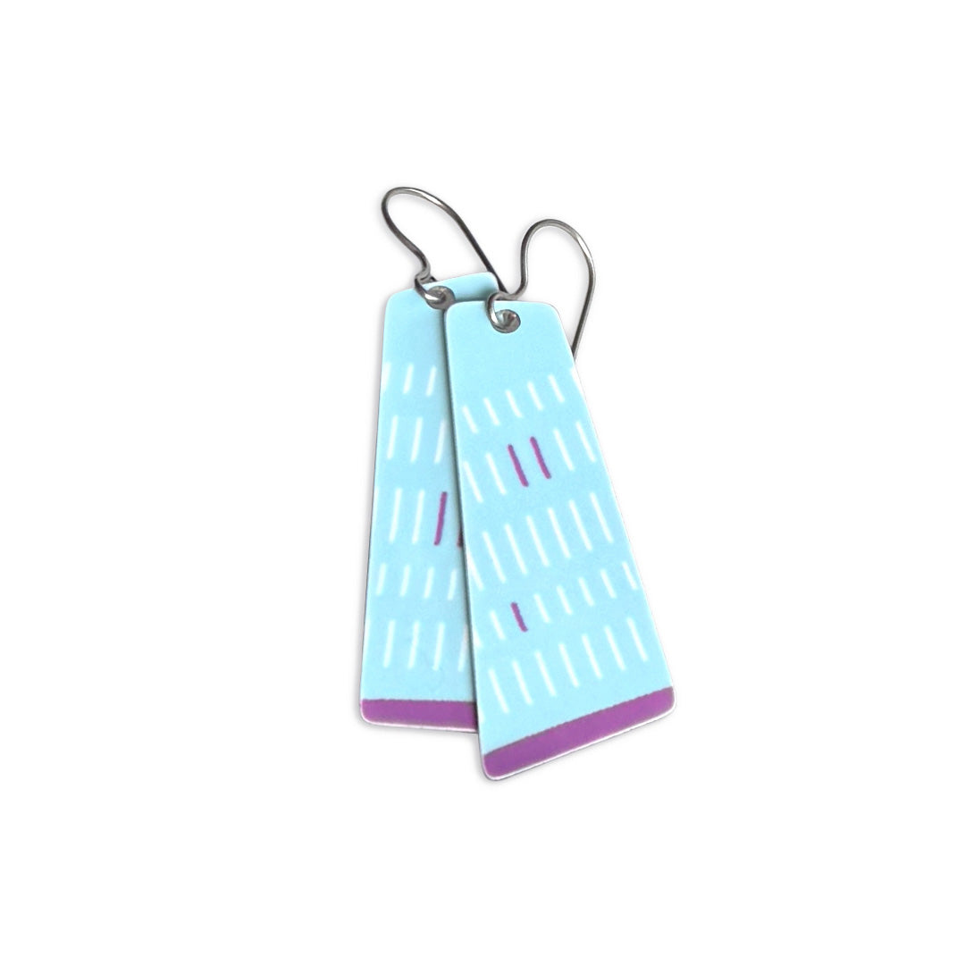 Pair of long, light blue earrings with purple accents on a white background.