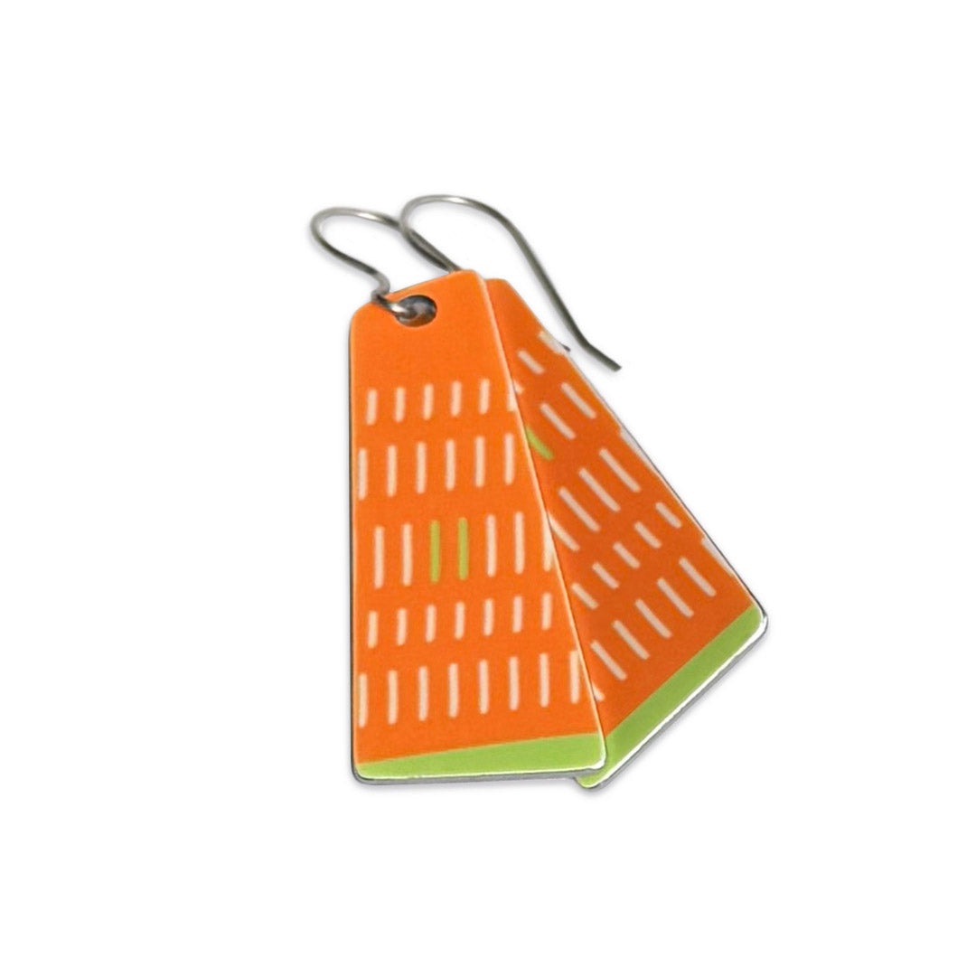 Bright orange and green earrings with geometric pattern on a white background.