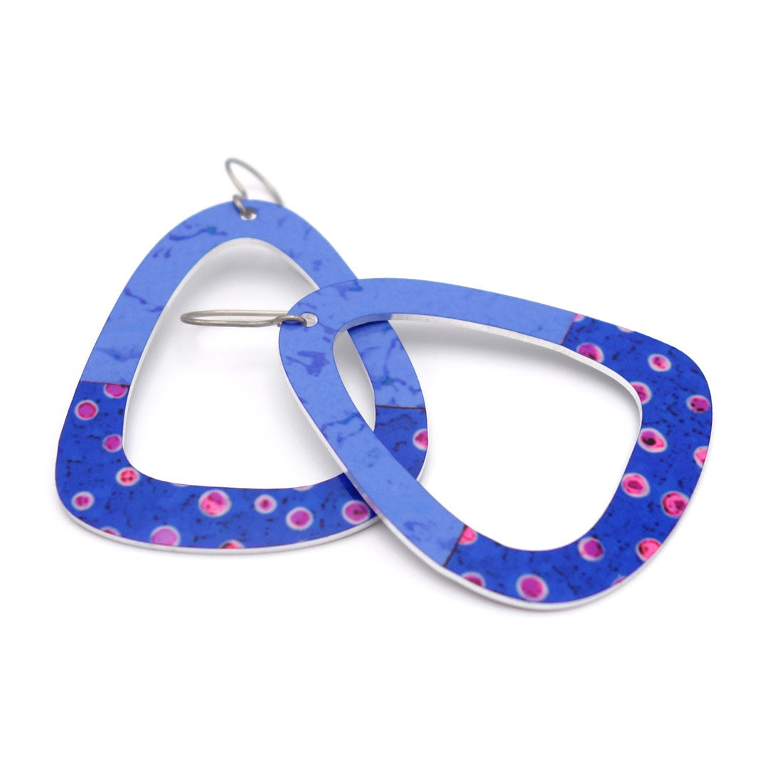 Large, triangular-shaped dangle earrings with blue and pink polka dot design on a white background.
