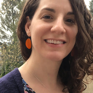 Girl wearing small leaf earrings in orange by ColorUpLife.