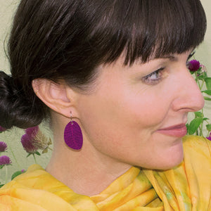 Woman wearing plum colored small leaf earrings by ColorUpLife.