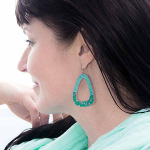 Woman wearing the large smokey teal triangle earrings with polka dots by ColorUpLife.