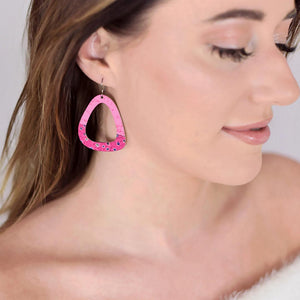 Woman wearing then large pink triangle earrings with polka dots by ColorUpLife.
