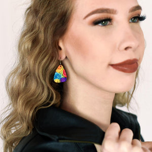 A young lady wearing a pair of colorful, abstract floral dangle earrings in rainbow by ColorUpLife